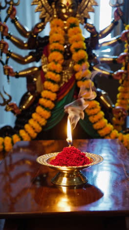 hindu prayer with goddess statue and incense