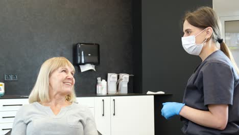 a grandmother is talking to a dentist while sitting in a chair. checks the condition of old teeth. the doctor consults the patient. modern dentistry