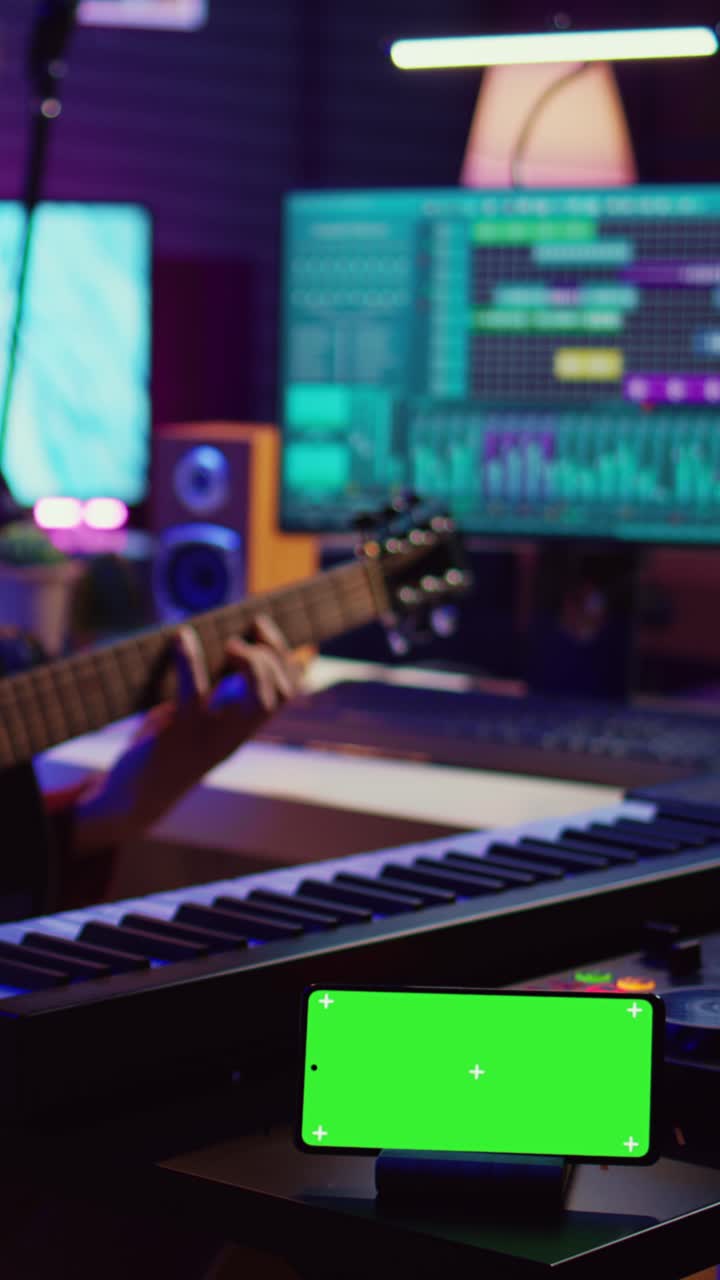 Smartphone with Green Screen in Music Studio with Musician Playing Guitar