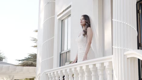 bride posing by balcony as she is photographed