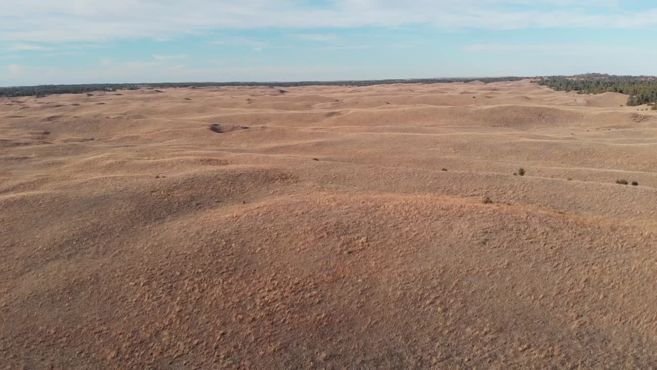 drone disparado mientras vuela hacia adelante sobre la pradera montañosa en un día soleado en nebraska