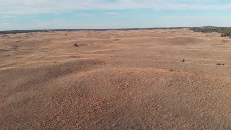 drone shot as it flies forward over the hilly prairie on a sunny day in nebraska