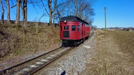 a rail car traveling along a lonely track on a sunny winter day
