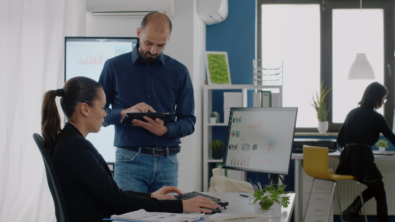 Businesswoman talking to man with digital tablet about project