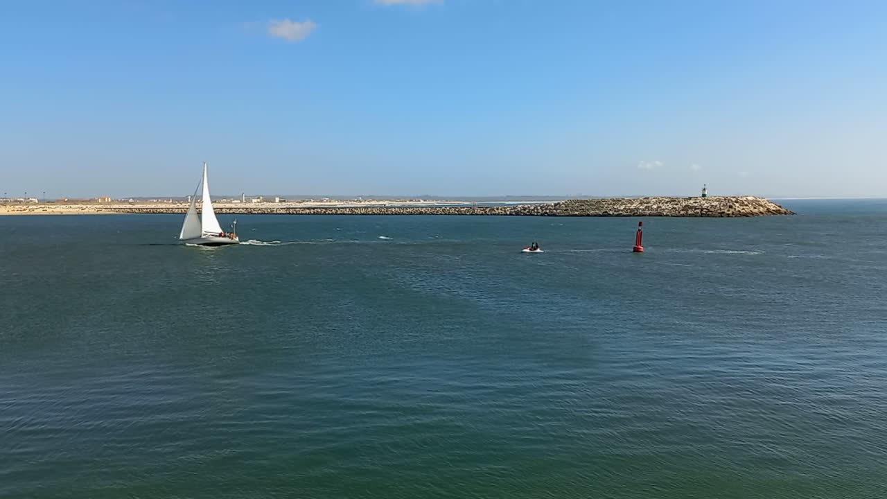 entrada a la desembocadura de mondego con un pequeño velero en el fondo