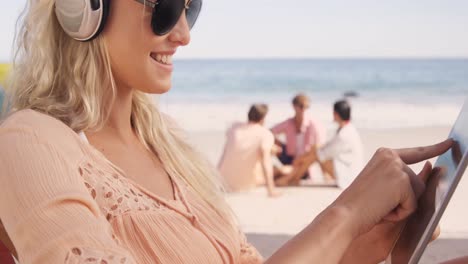 mujer acostada en su silla de sol con su tableta