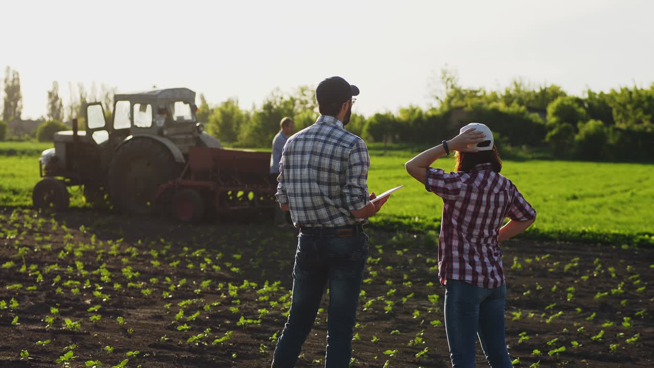 dos agricultores hablan en el campo, usan una tableta