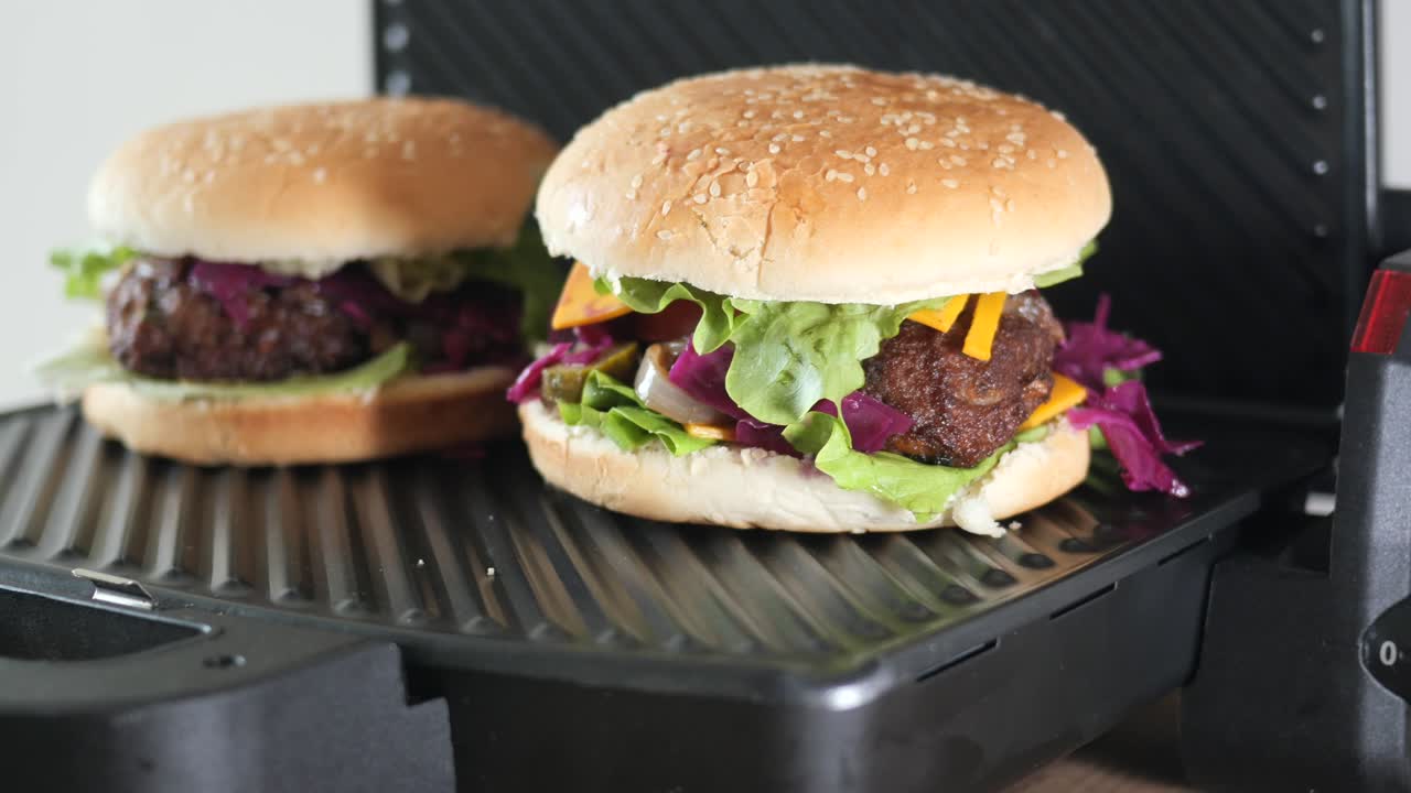 dos deliciosas hamburguesas siendo asadas