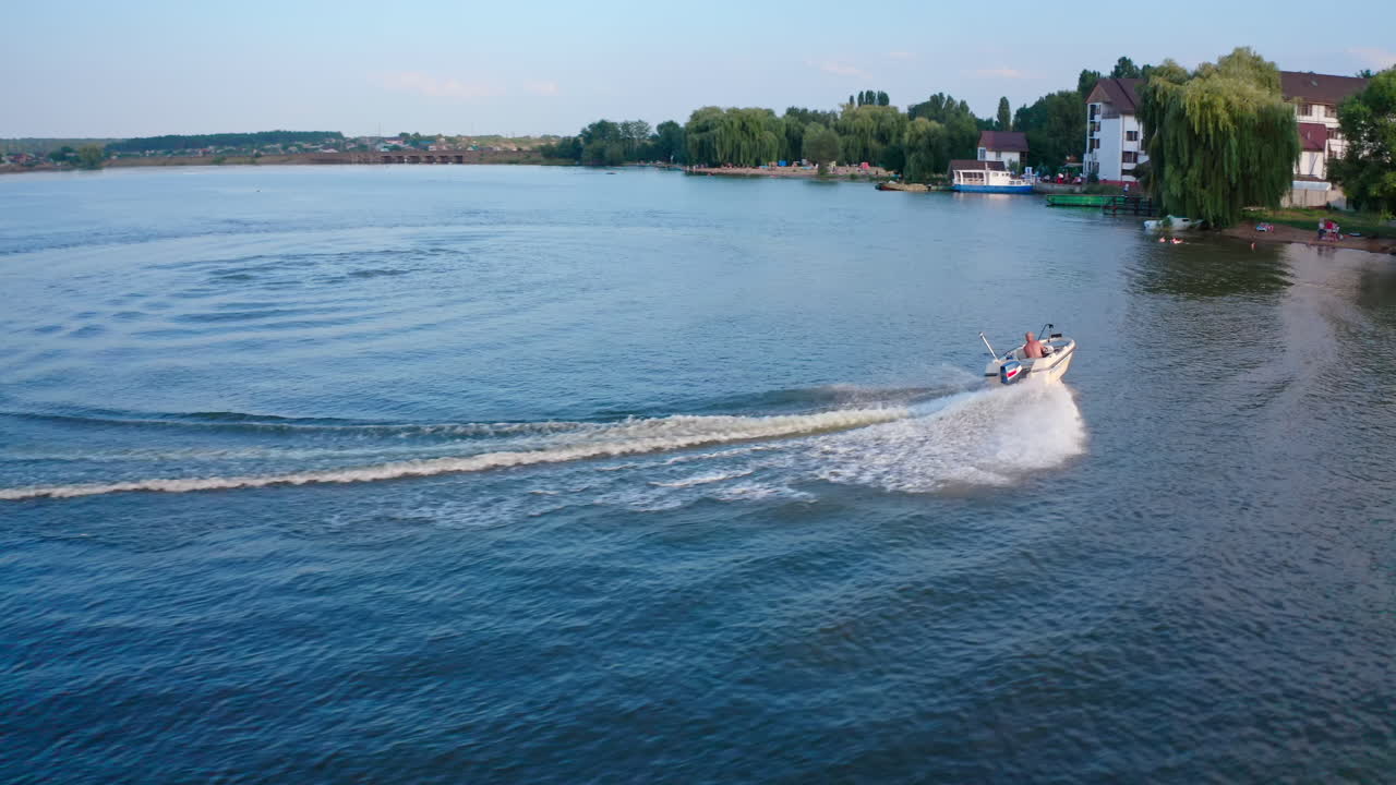 Motor boat sails on river. Aerial footage of speed boat crossing on river