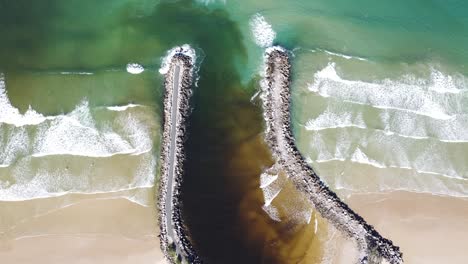 drone aerial top view of a river mouth and the waves breaking in australia