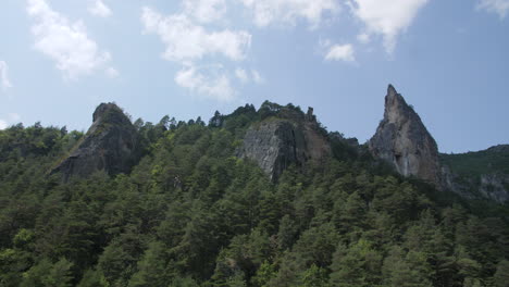 three rocky peaks in a coniferous forest gorges du tarn canyon france