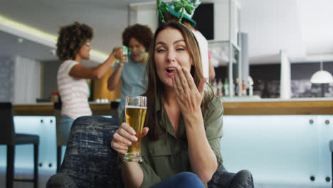 un grupo diverso de amigos felices celebrando el día de san patricio bebiendo cervezas en un bar