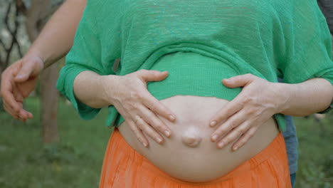 parent hands on belly with unborn child