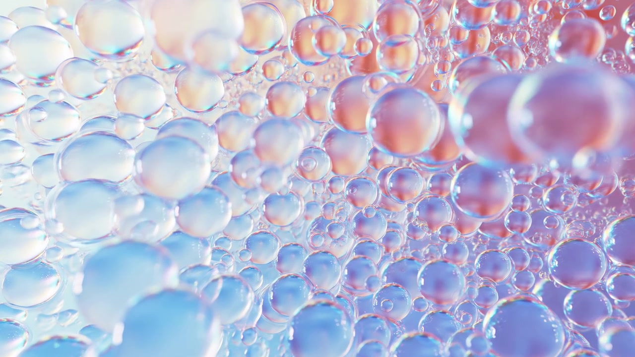 Primo piano macro astratto di sfere e bolle traslucide lucide con riflessi iridescenti, che si sovrappongono su una sfumatura rosa-blu tenue.