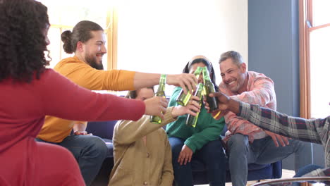 Happy-diverse-male-and-female-friends-relaxing-at-home-together-and-drinking-beers