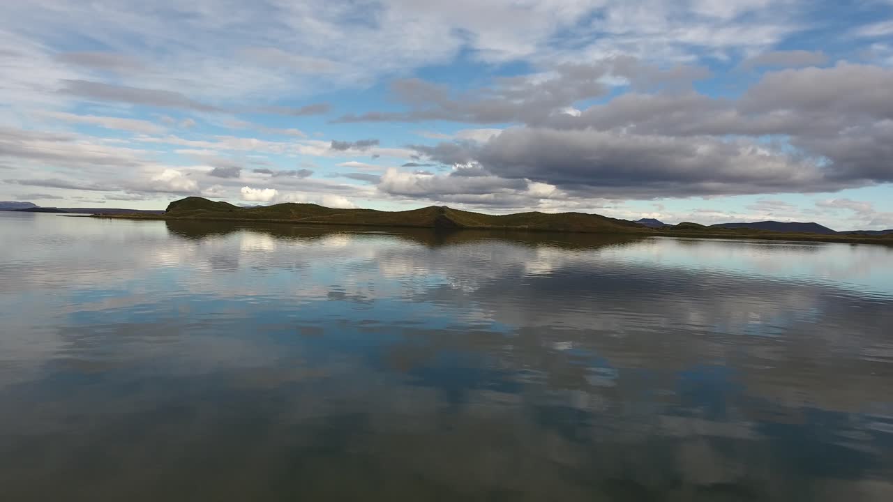 imagen aérea de un dron volando sobre el lago myvatn en islandia cerca de la superficie del agua.