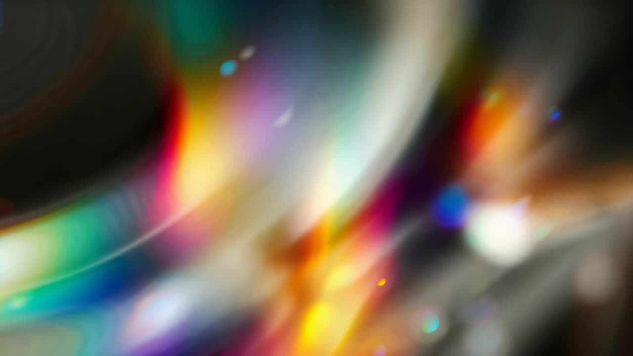 Light passing through glass prism creating flares drifting on beige backdrop, forming rainbow arcs