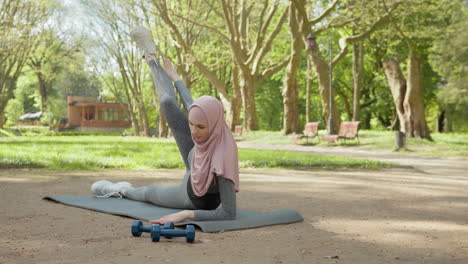 woman exercising in a park wearing a hijab