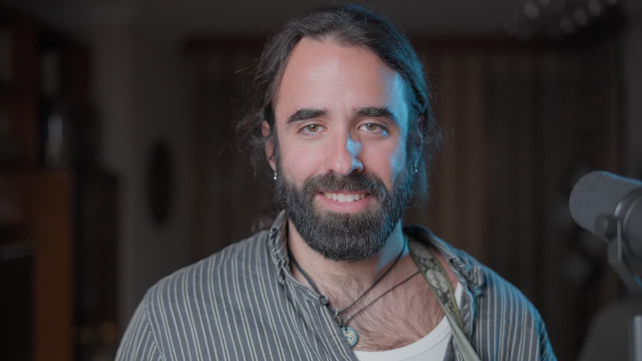 Man with beard smiling for a podcast or interview