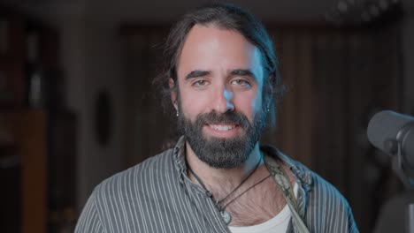 man with beard smiling for a podcast or interview