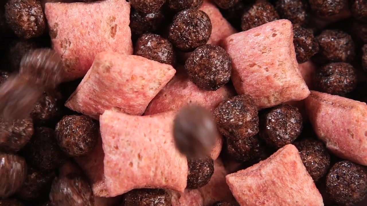 Chocolate Cereal Balls Falling onto Pink Cereal Pillows