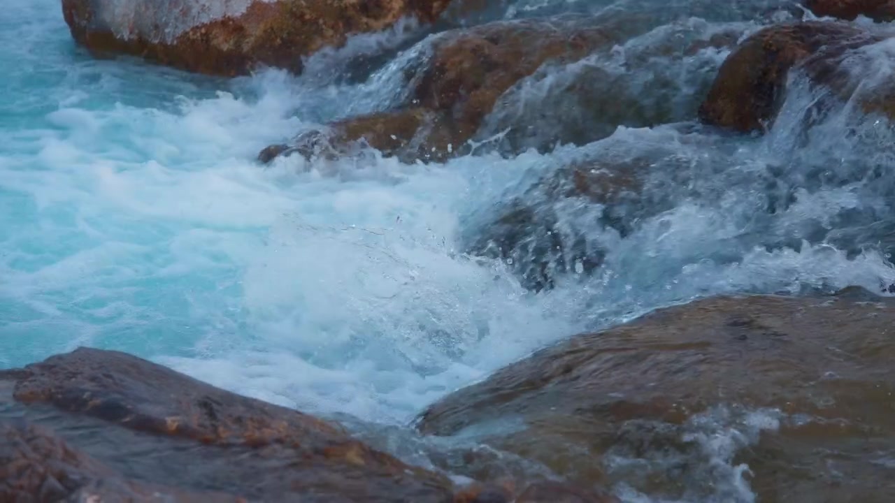 Primo piano di un ruscello di montagna che scende a cascata dalle rocce.