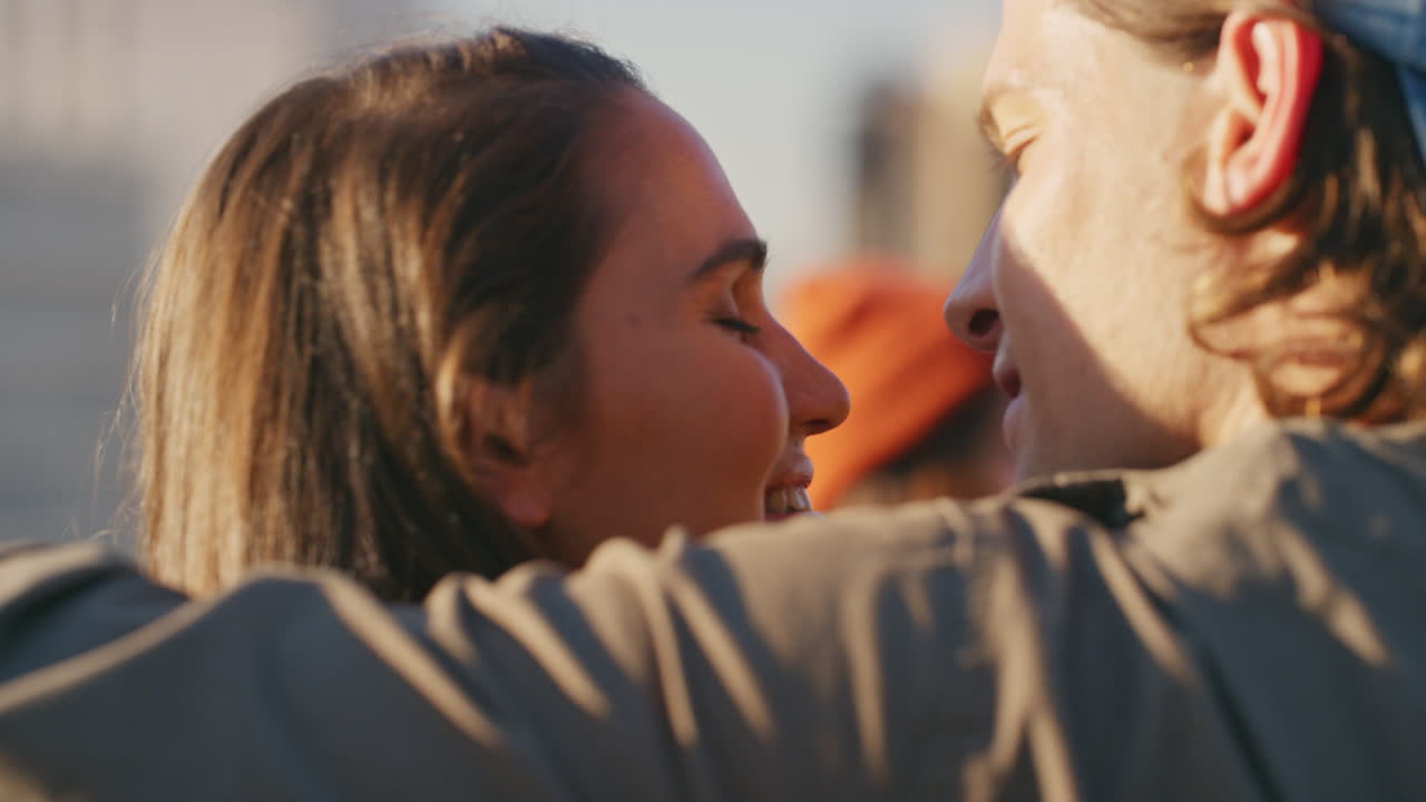 un grupo feliz de amigos celebrando en el techo una pareja caucásica besándose disfrutando de la celebración del fin de semana al atardecer