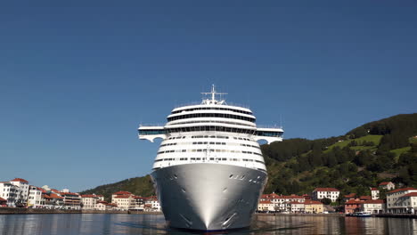 large cruise ship docked in a coastal town harbor