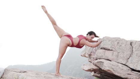 woman in yoga pose on rocks