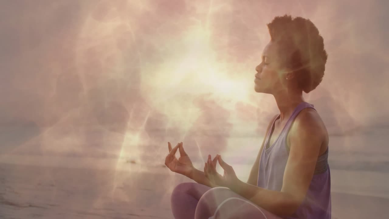 Donna che espira e richiama un'aura dorata vorticante durante una meditazione per la salute all'alba sulla riva.