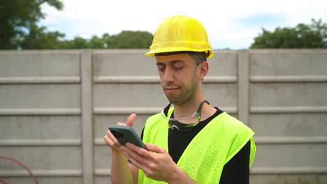 Ein-Bauarbeiter-Ist-Mit-Den-Auf-Seinem-Telefon-Empfangenen-Angaben-Einverstanden---Mittlere-Nahaufnahme