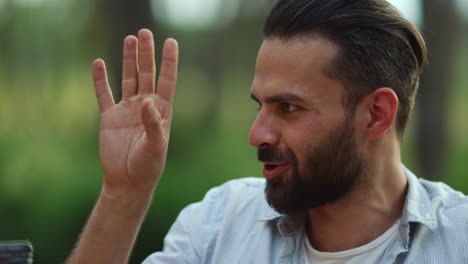 Attractive-guy-telling-story-on-backyard.-Man-making-hand-gestures-outdoors