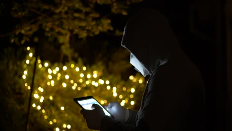 man with gloves and mask reading news about coronavirus on tablet. covid-19 news. self-isolation, quarantine, pandemic concept