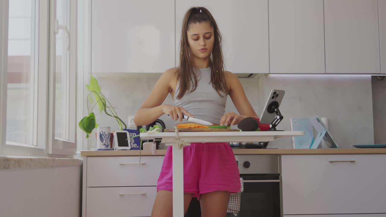 Young woman chopping vegetables in a modern kitchen