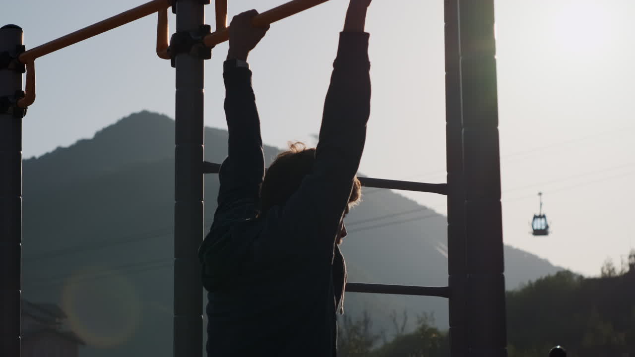 야외 체육관 에서 풀업 을 하는 남자