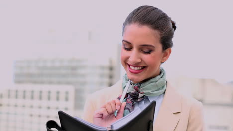 una mujer hermosa y elegante escribiendo en un diario.