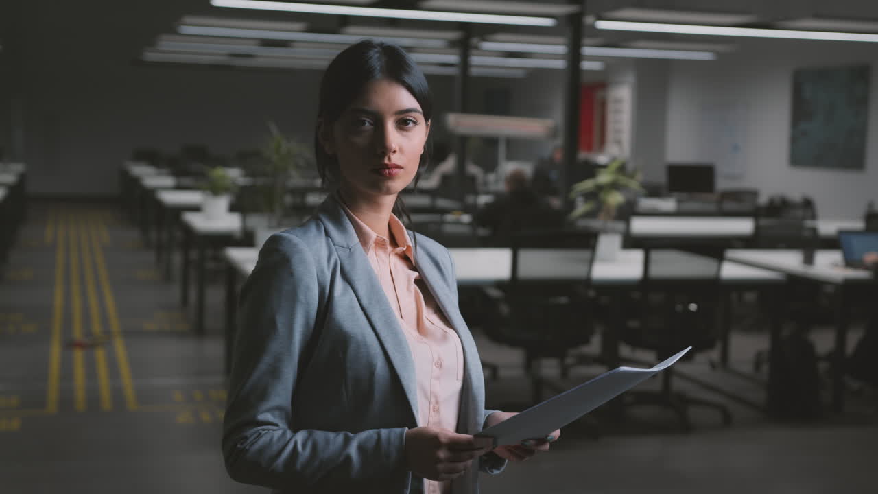 Professional Businesswoman Standing in a Modern Office with Documents