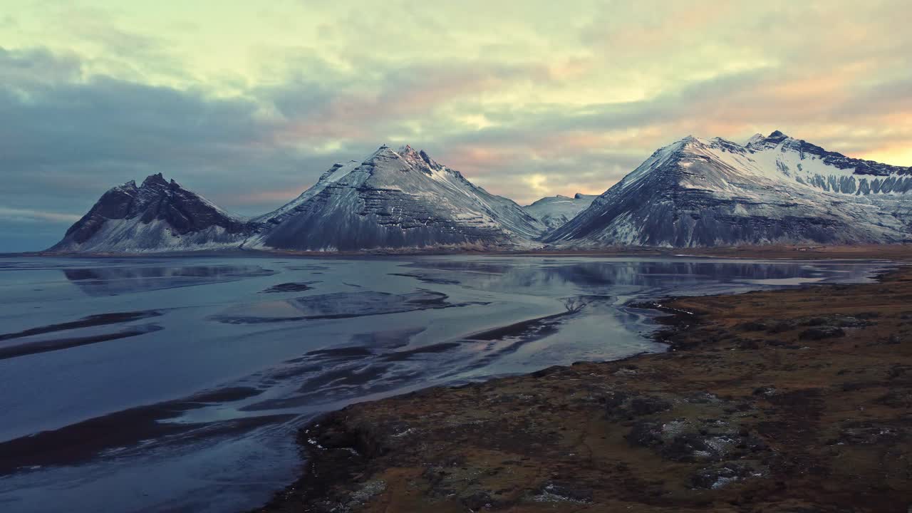 Snowy mountains against sundown sky