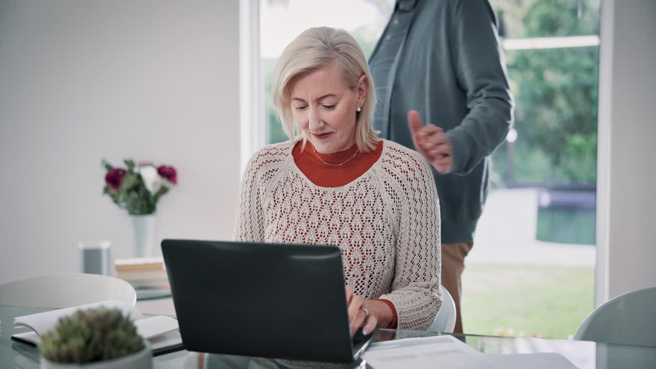 Een ouder echtpaar dat samen een laptop gebruikt