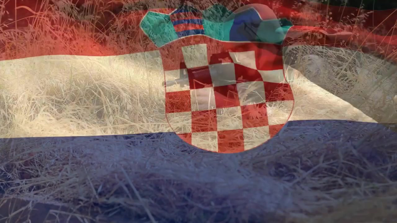 Falująca, półprzezroczysta nakładka flagi, ukazująca kolarza w kasku wyłaniającego się z trawy, naprawiającego rower na potrzeby turystyki.