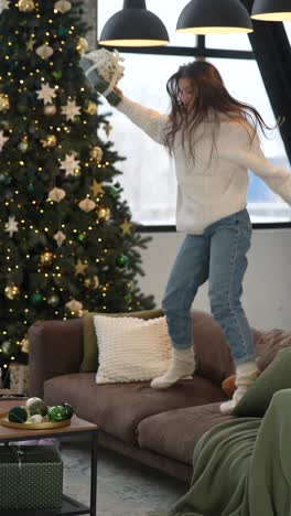 excited girl celebrating christmas on a sofa