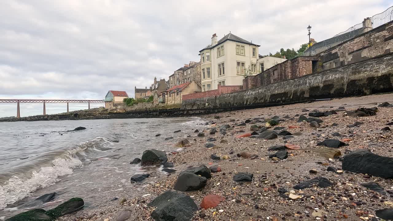 파도가 부드럽게 바위가 있는 해안에 부히고