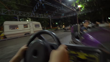 Niño-Divirtiéndose-Conduciendo-Un-Auto-Chocador-En-La-Feria-De-Diversión