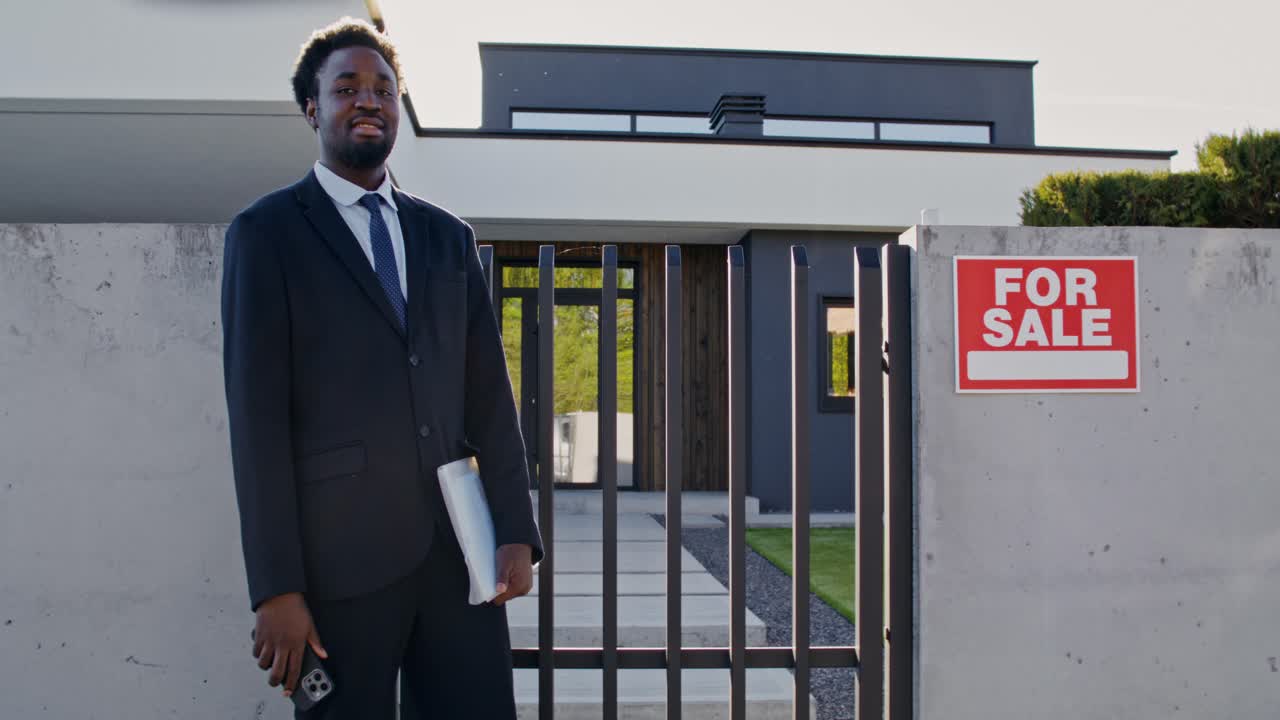 Real Estate Agent in front of a Modern House for Sale