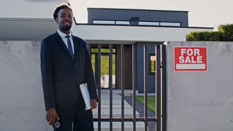 real estate agent in front of a modern house for sale