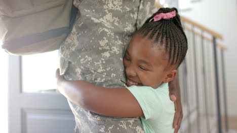 african american daughter embraces a father in a military uniform