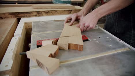 close up. master cuts a wooden board with a circular saw in the woodworking workshop of a small furniture manufacturer. slow motion. top view