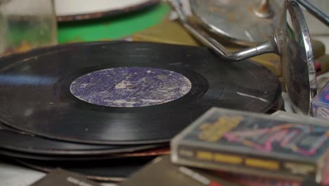 vintage vinyl stickers and old cassettes stacked on the table in an old room