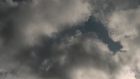 Time-Lapse-of-clouds-rolling-past,-backlit-by-late-afternoon-sun-in-springtime-4K