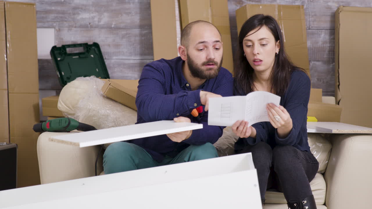 Couple Assembling Furniture Following Instructions